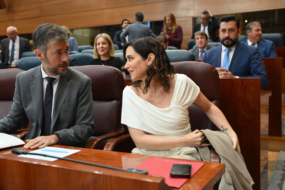 La presidenta de la Comunidad de Madrid, Isabel Díaz Ayuso, conversa con su consejero de Presidencia, Justicia y Administración Local, Miguel Ángel García, en la Asamblea de Madrid, el pasado mayo.FERNANDO VILLAR (EFE)