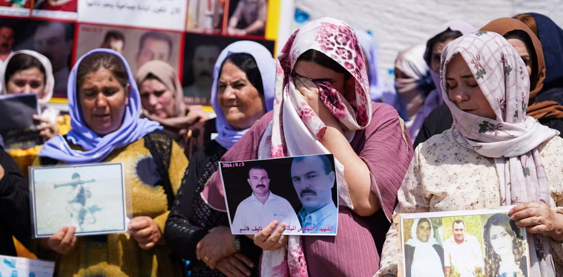 Mujeres yazidíes iraquíes lloran mientras sostienen fotografías de víctimas y familiares desaparecidos durante una ceremonia celebrada en la región iraquí del Kurdistán para conmemorar el 10º aniversario del genocidio yazidí. Ismael Adnan/SOPA Images/LightRocket via Getty Images