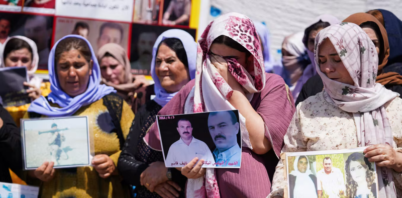 Mujeres yazidíes iraquíes lloran mientras sostienen fotografías de víctimas y familiares desaparecidos durante una ceremonia celebrada en la región iraquí del Kurdistán para conmemorar el 10º aniversario del genocidio yazidí. Ismael Adnan/SOPA Images/LightRocket via Getty Images