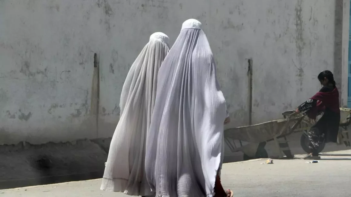 Fotografía del 22 de agosto de 2024 en donde mujeres afganas vestidas con burka caminan por una carretera en Kandahar, Afganistán. EFE/QUDRATULLAH RAZWAN