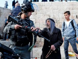 Una soldado israelí sostiene su arma ante un anciano palestino. Foto: StoptheWall