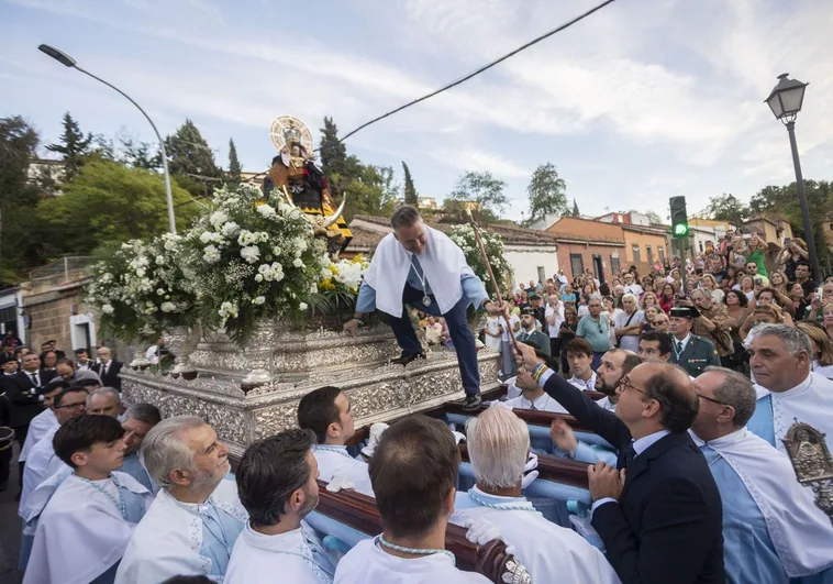 El alcalde (PP) de Cáceres entrega el bastón de mando a la Virgen de la Montaña durante la procesión.