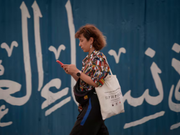 Una mujer consulta su móvil mientras camina sin velo por Teherán, el 30 de junio.NurPhoto (NurPhoto via Getty Images)