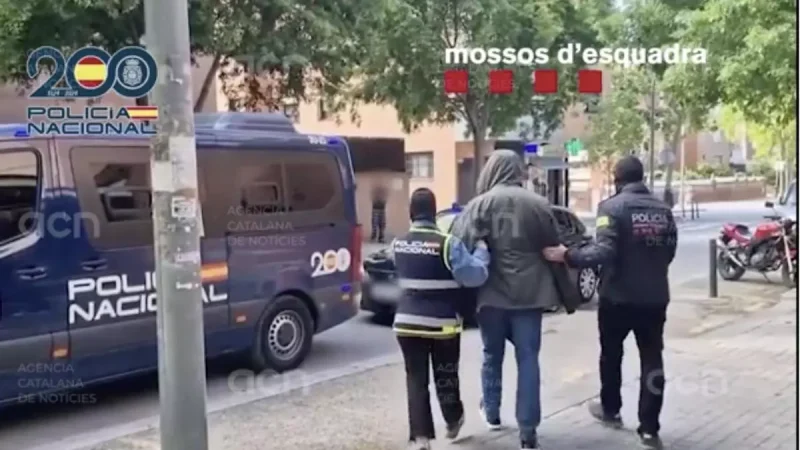 Agentes de la Policía Nacional y de los Mossos d'Esquadra, con uno de los detenidos.