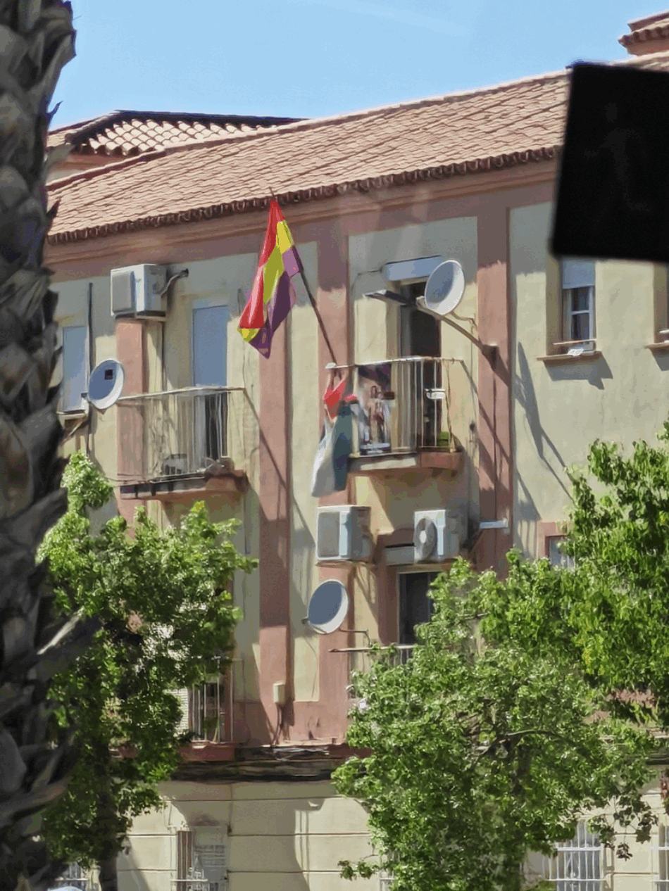 Balcón en Málaga con bandera republicana, bandera palestina y cartel cristiano